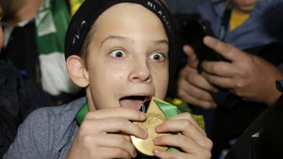 A boy displays the winners medal given to him by Sonny Bill Williams of New Zealand 