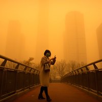 Foto: Smilšu vētra pārkrāso Pekinas debesis oranžos toņos