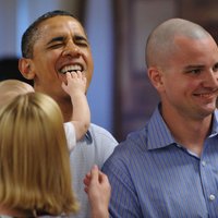 Zīdainis iebāž roku Baraka Obamas mutē