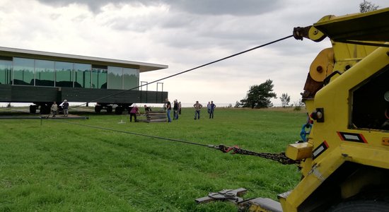 Foto: Evakuators aizvelk 'Māju-kuģi' pa pļavu; Lūsiņš 'piemirsis' informēt VVD