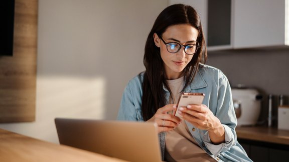 sieviete ar telefonu, attālinātais darbs