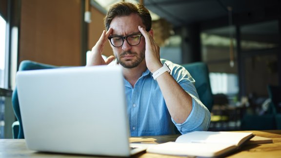 vīrietis darbs dators galvassāpes stress