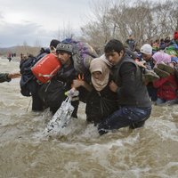 Foto: Simtiem migrantu no Grieķijas izlaužas cauri Maķedonijas robežai