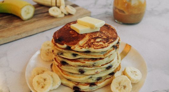 Классические блины с кусочками шоколада, поданные с бананом и кленовым сиропом