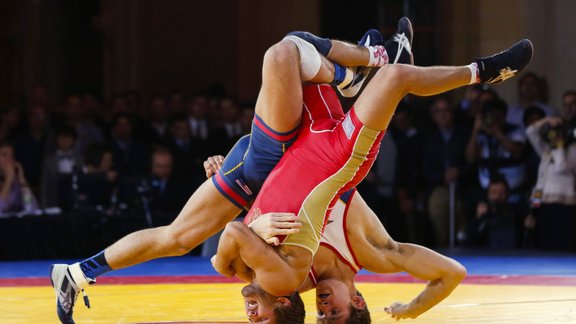 Russia s Saba Khubetzhty (L) and David Taylor of the U.S. flip over on their heads during the Rumble on the Rails wrestling event