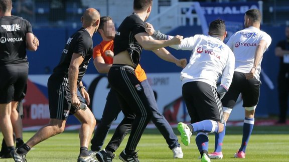 A Bastia supporter fightsn Lyons player