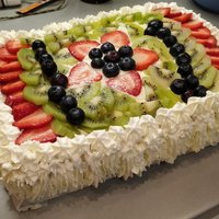 Greznā lauku torte ar vārīto krēmu, augļiem un putukrējumu