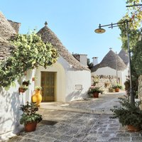 Gleznainais Alberobello ciems Itālijā ar miniatūrām mājām un noņemamiem jumtiem