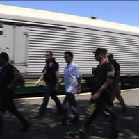 Video: Separātisti EDSO novērotājiem parāda vagonus ar aviokatastrofā bojāgājušo ķermeņiem