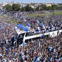 Foto, video: Argentīnas futbolistus mājās sagaida miljoniem cilvēku un drošības nolūkos eskortē ar helikopteriem