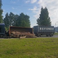 ФОТО, ВИДЕО: На ул. Дарзциема опрокинулся грузовик с гусеничными лентами