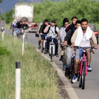 Foto: Tūkstošiem imigrantu pa Eiropu rullē ar divriteņiem