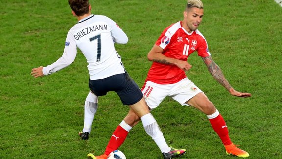 Switzerland s Valon Behrami fights for the ball against France s Antoine Griezmann