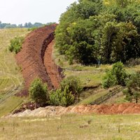 Foto: Ukraina uz robežas rok grāvi, lai liktu šķēršļus kara tehnikas iebrukumam no Krievijas