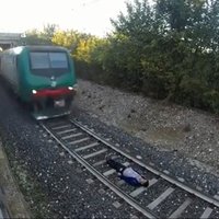 Video: Jaunietis paguļas zem braucoša vilciena