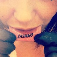 Liene Brikouska uz lūpas uztetovē vārdu 'SASHA'