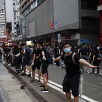 Honkongas ielās iziet desmitiem tūkstoši protestētāju maskās