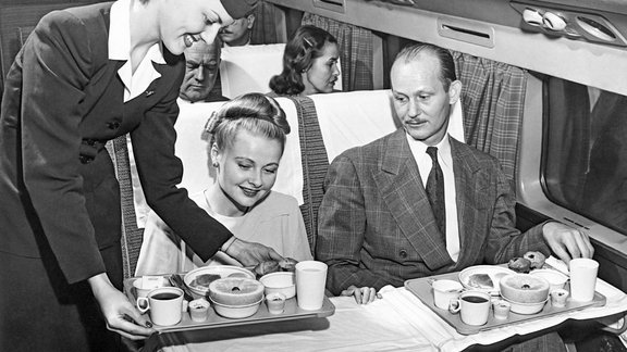 United States- c. 1958 A stewardess serves a meal to a couple on an American Airlines flight.-4