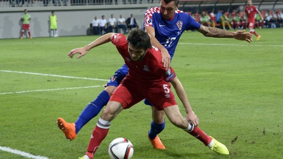 Badavi Huseynov (L) of Azerbaijan vies for a ball with Mario Mandzukic of Croatia