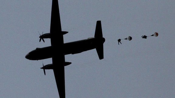 paratroopers jump from an AN-26 aircraft