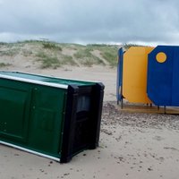 ФОТО: В Вентспилсе затопило пляж, кругом валяются мусорные контейнеры и биотуалеты
