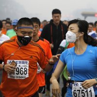 Foto: Smoga dēļ Pekinas maratona dalībniekiem jāskrien aizsargmaskās