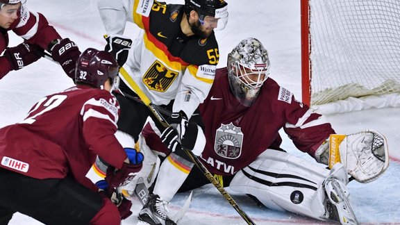 Germany s player Felix Schutz and Latvia s goalie Elvis Merzlikins