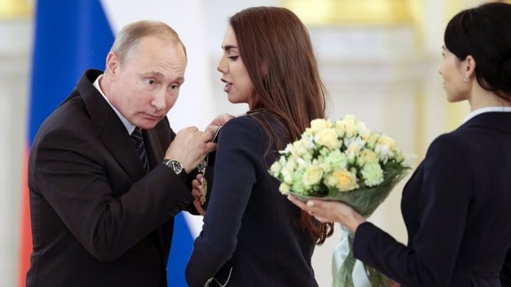 Russian President Vladimir Putin, left, listens to Russia s Margarita Mamun