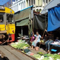 Galvenais, ka andele – vilciens Taizemē, kas brauc cauri tipiskam Āzijas tirgum