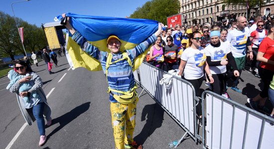 Foto: Smaidīga tauta ar dažādiem karogiem pieveic Rīgas maratonu