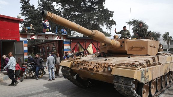 Turkish soldiers atop a tank patrol the northwestern city of Afrin, Turcijas karavīri, Afrīna