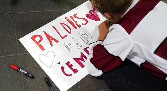 Foto: Vairāki līdzjutēji nakts tumsā sagaida hokejistus pēc pasaules čempionāta