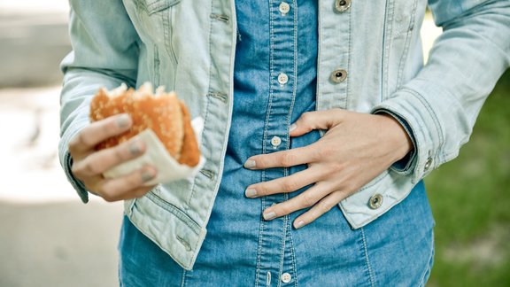 vēdera sāpes burgers sieviete