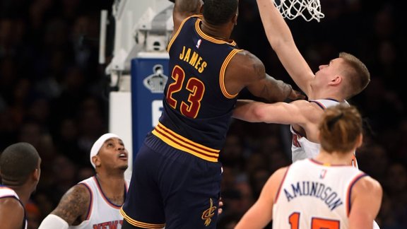 leveland Cavaliers forward LeBron James (23) shoots a basket over New York Knicks forward Carmelo Anthony (7), forward Kristaps Porzingis (6) and forward Lou Amundson (17) 