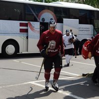 Foto: Latvijas hokejisti no autobusa izkāpj pilnā ekipējumā ar slidām kājās