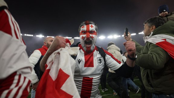 Georgia fans invade the pitch after their team won the UEFA EURO 2024 qualifying play-off final football match between Georgia and Greece in Tbilisi on March 26, 2024. (Photo by Giorgi ARJEVANIDZE / AFP)