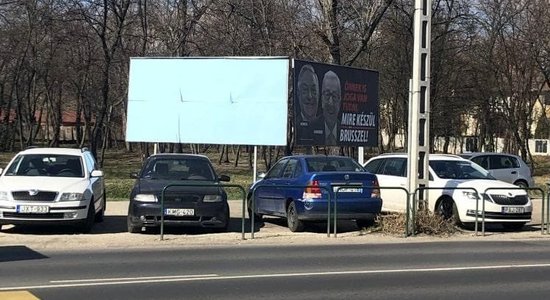 Foto: Vēbera vizītes laikā Ungārijā aizmālē Junkeru un Sorosu nomelnojošus plakātus