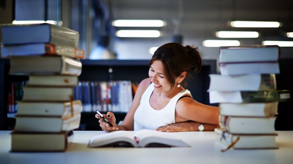 sieviete studente mācibas bibliotēka