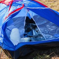 Lietuviešu tūristi Liepājā pie Aizsardzības ministrijas noliktavas ceļ telti