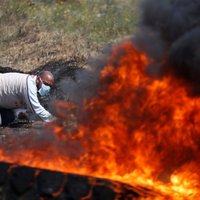 Foto: Melnos riepu dūmu mutuļos palestīnieši protestē pret vēsturisko zemju atņemšanu