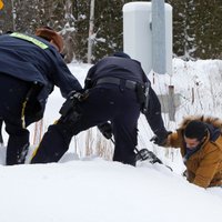 Foto: Migranti no ASV brien pāri robežai uz Kanādu