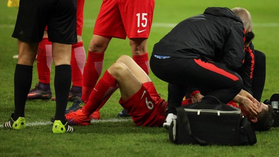 Poland Robert Lewandowski receives medical assistance after fire cracker