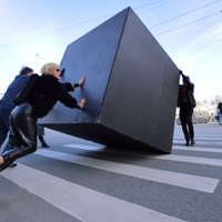 Foto: Rīgas centrā notikusi performance – melnā kuba velšana