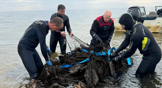 Foto un video: No Rīgas jūras līča izvelk trīstonnīgu vecu zvejas tīklu murskuli