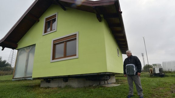 Vojin Kusic s stands in front of his rotating house in a town of Srbac