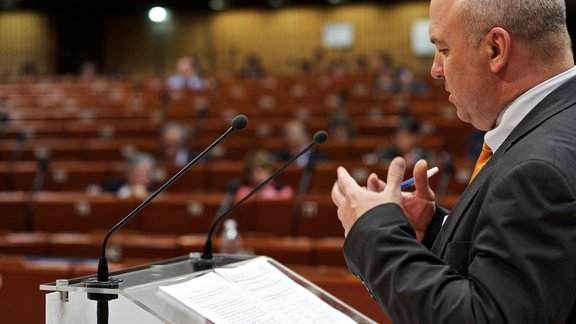 Nils Muižnieks ir ietekmīgs cilvēks citā Eiropas organizācijā - Eiropas Padomē. Viņš tur ir galvenais cilvēktiesību komisārs, un attiecīgi viņam var sūdzēties, ja, piemēram, cietumā jūs slikti baro, vai ja jūsu dzimtajā miestā nav ielu plāksnītes jums saprotamā valodā.