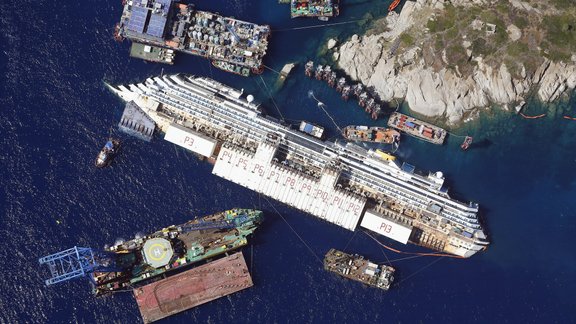 An aerial view shows the Costa Concordia as it lies on its side next to Giglio Island taken from an Italian navy helicopter