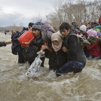 Foto: Simtiem migrantu no Grieķijas izlaužas cauri Maķedonijas robežai