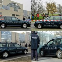 Merkeles biroja vārtos ietriekusies ar grafiti apzīmēta automašīna