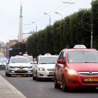 Foto: Vairāki desmiti taksometru dodas protesta braucienā ap Ministru kabinetu